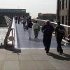 People walking across footbridge.